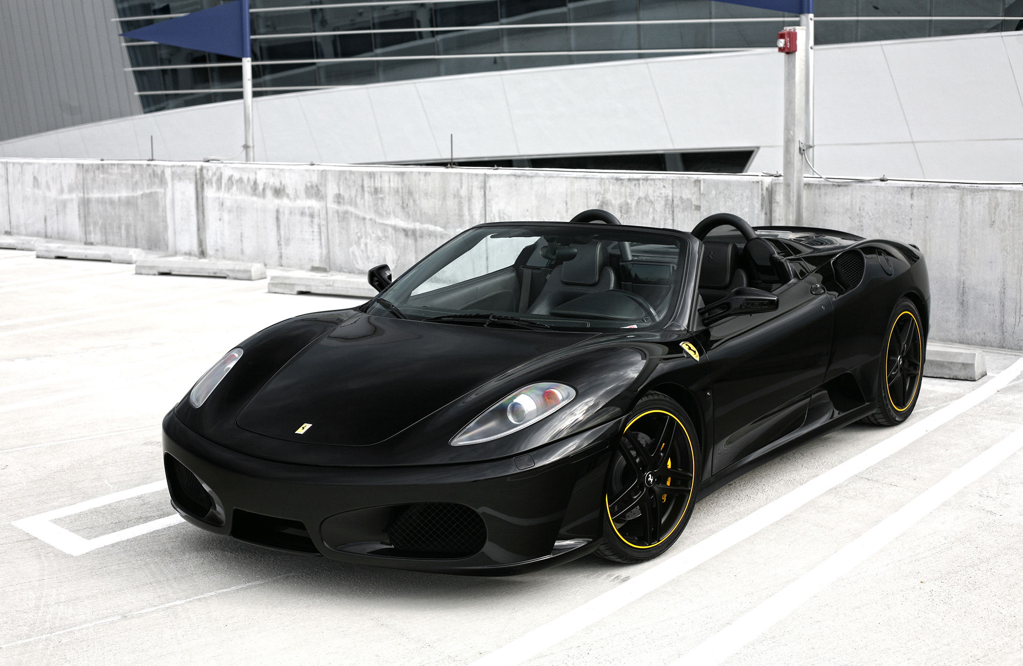 Wallpaper #PUVNlo4B7YBJg1BVH6Dw9 A Sleek Black Ferrari F430 Spider Parked in a Parking Garage