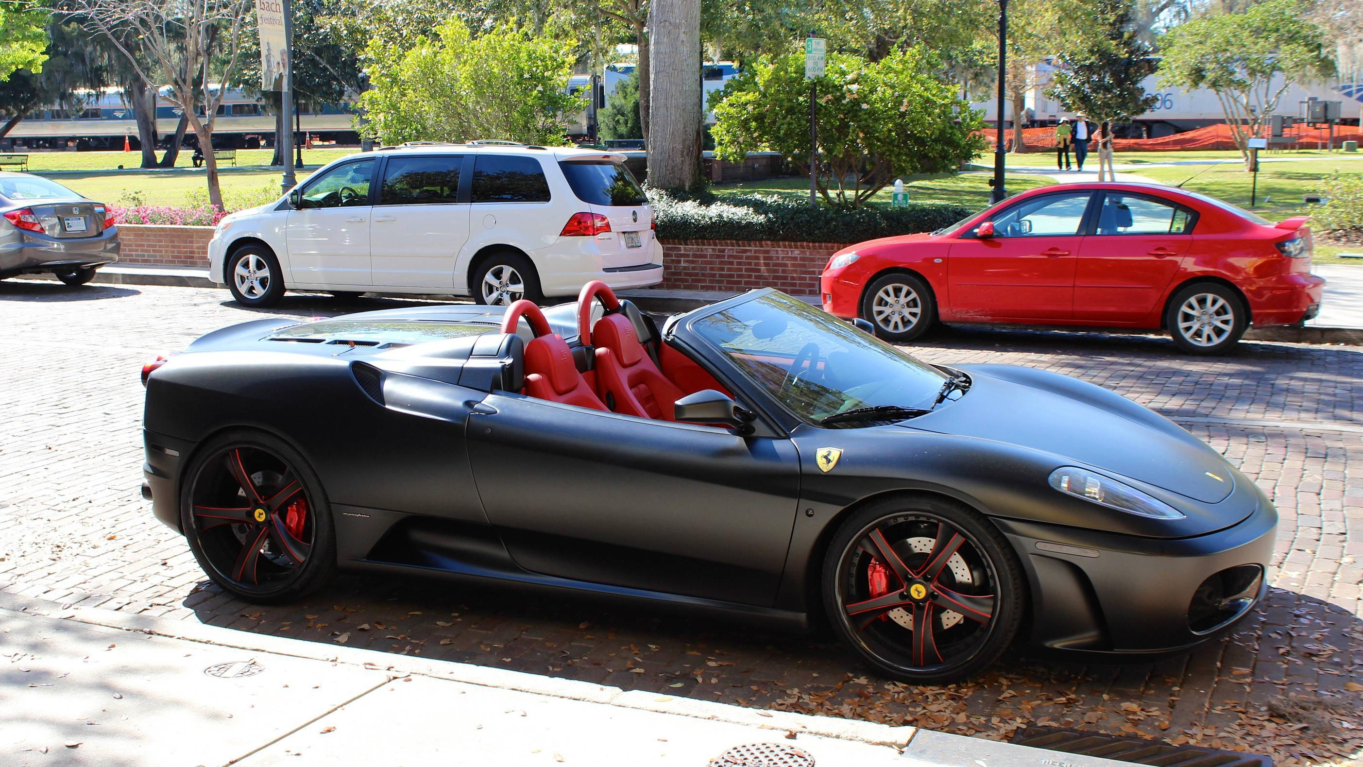 Wallpaper #PUVNlo4B7YBJg1BVH6Dw2 A Sleek Black Ferrari Parked on a City Street