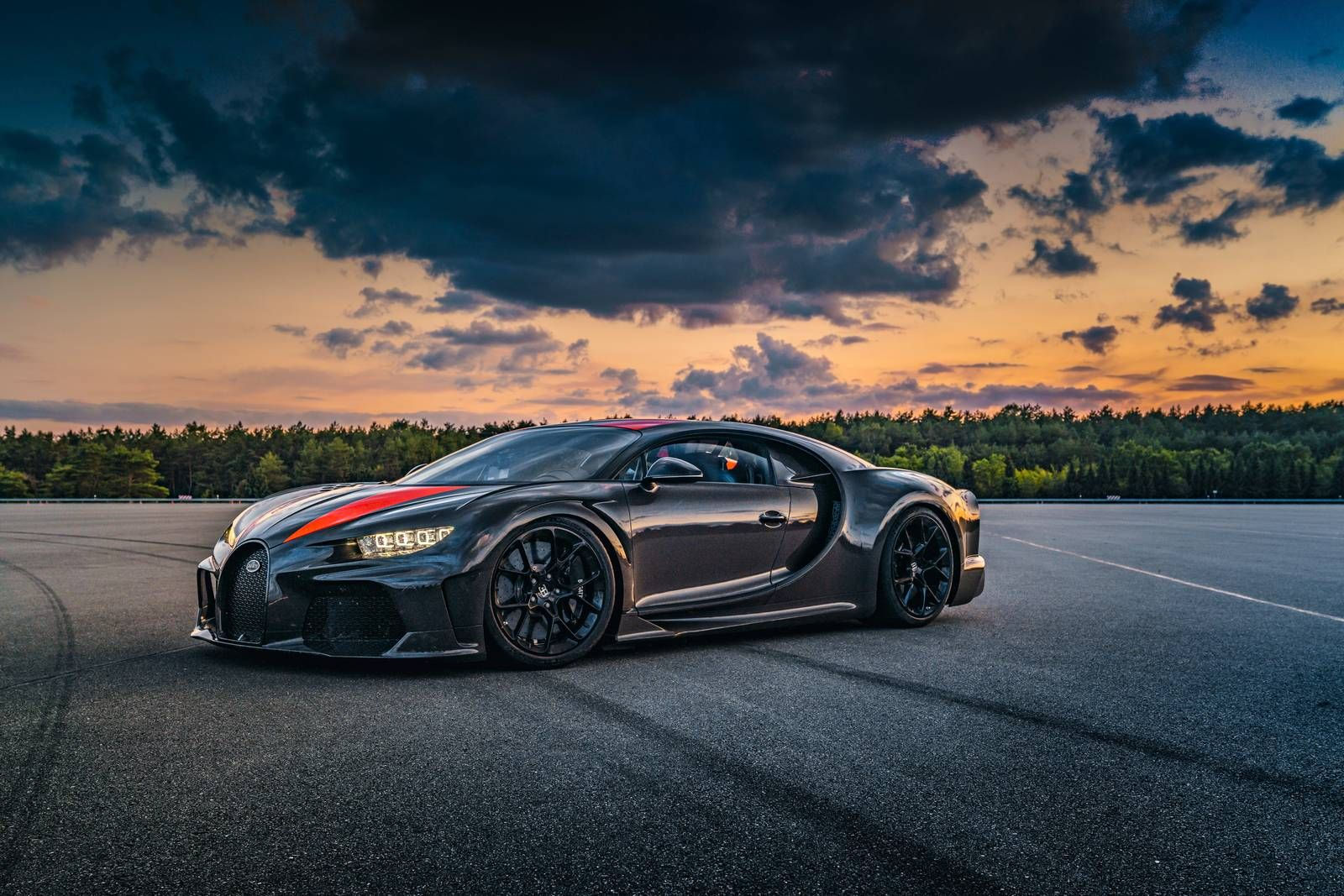 Wallpaper #mHOag44BFI5NbQksORvm46 A Sleek Black Bugatti Chiron Hypercar on an Empty Runway at Sunset