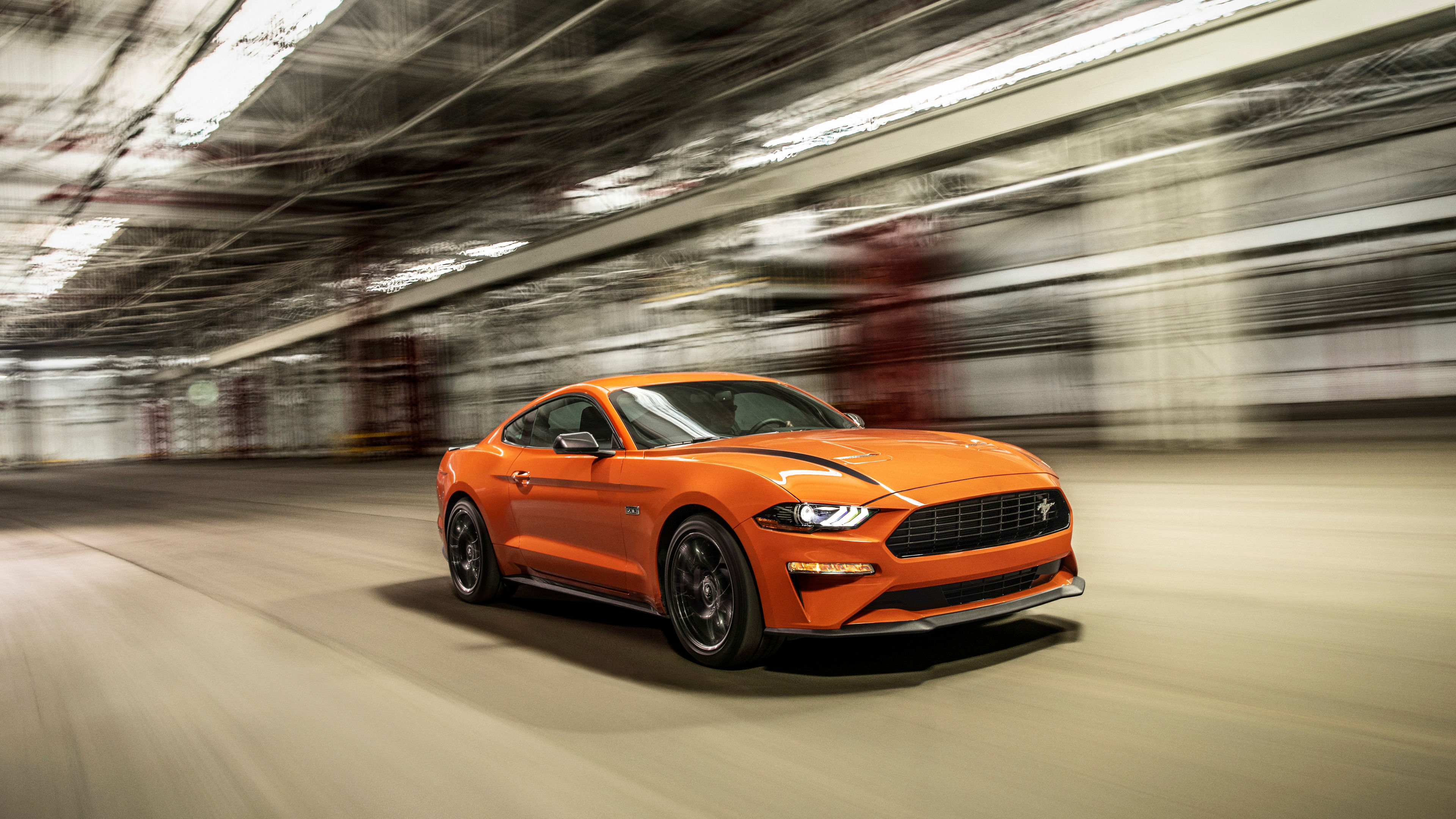 Wallpaper #_kWjoY4B7YBJg1BVvqN842 A Sleek Orange Ford Mustang GT Fastback Speeds Through a Dark Tunnel