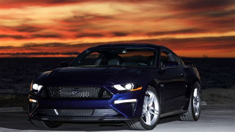 Wallpaper #YnP0fo4BFI5NbQksIxfN64 A Sleek Blue Ford Mustang Parked at Sunset