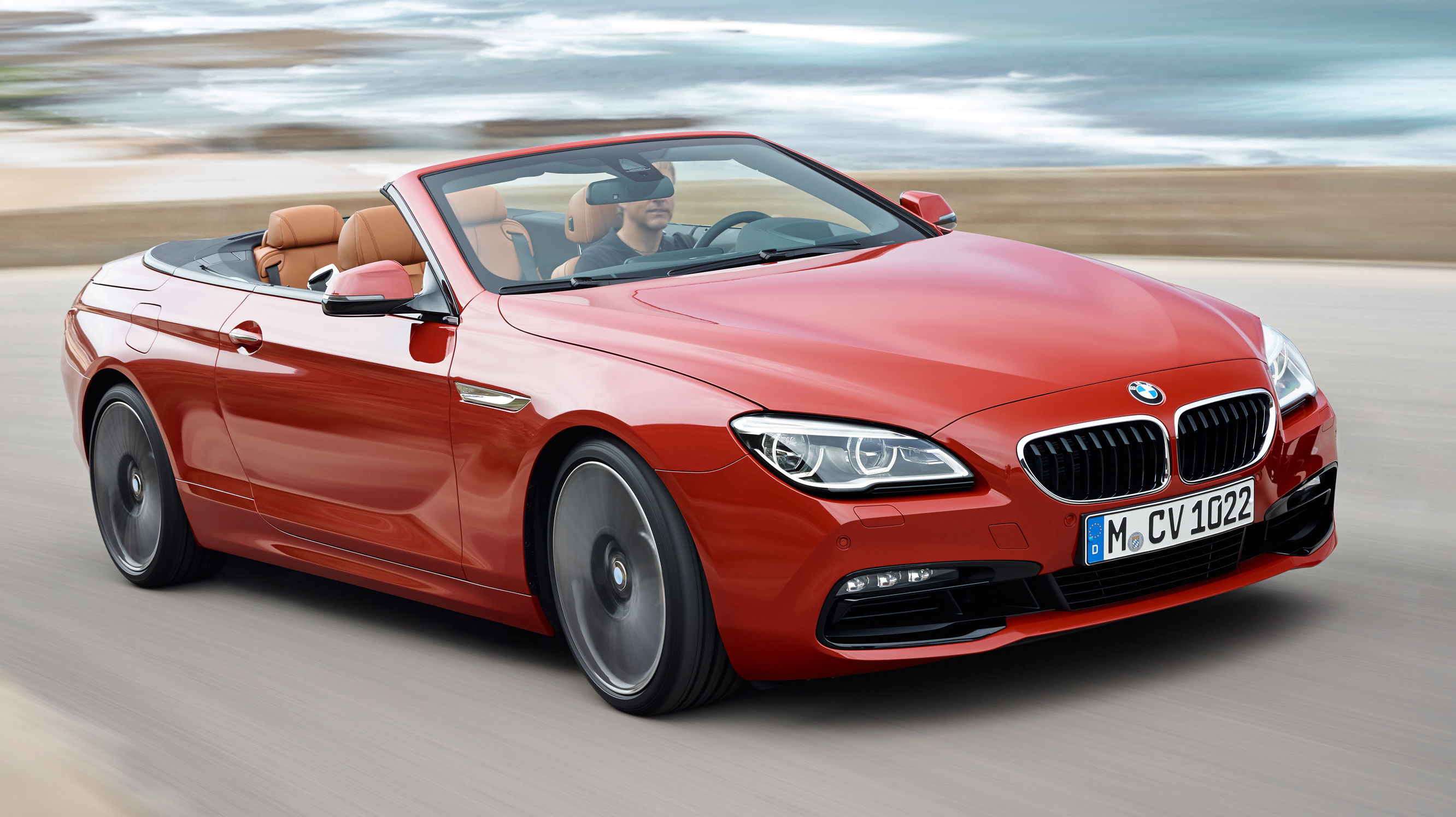 Wallpaper #VkVolo4B7YBJg1BVLqAC0 A Red BMW 6 Series Convertible Driving on a Coastal Road