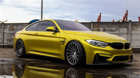 Wallpaper #YnP0fo4BFI5NbQksIxfN48 A Yellow  BMW  M4 Parked on a Rainy Day