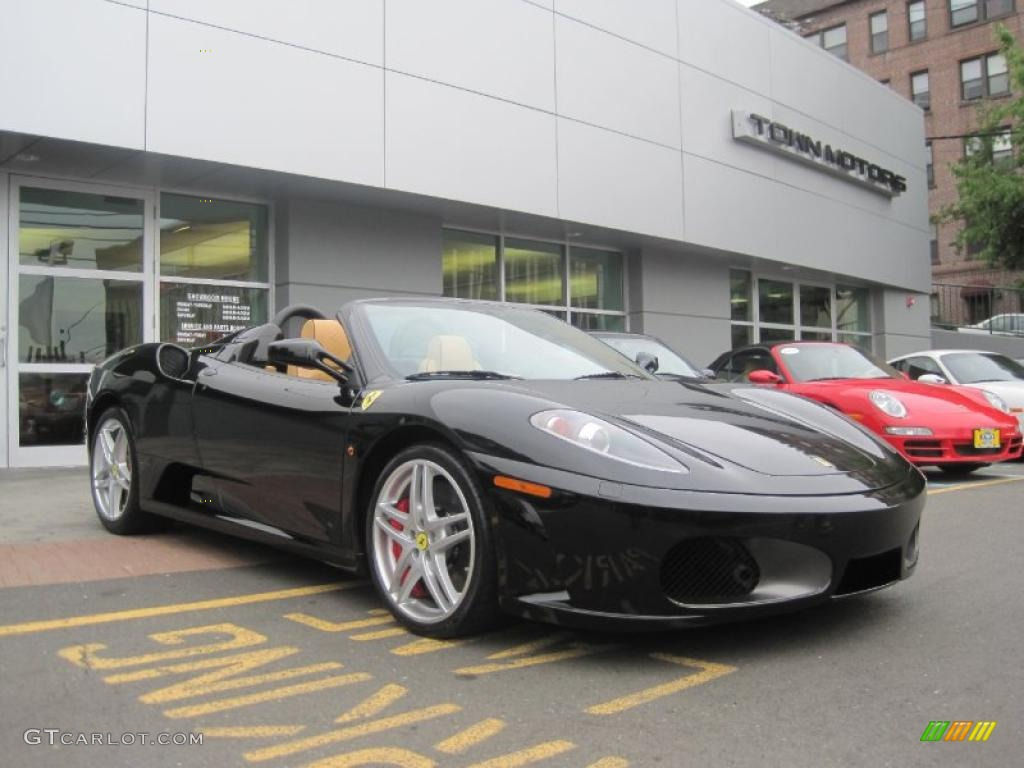 Wallpaper #PUVNlo4B7YBJg1BVH6Dw48 Black Ferrari F430 Spider with Yellow Interior Parked in Front of a Dealership