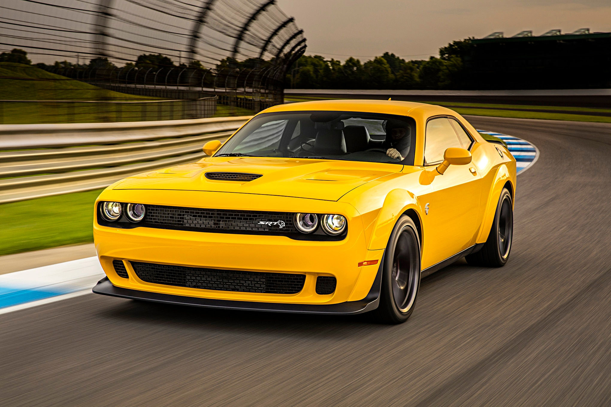 Wallpaper #-BWPso4BmMigT4UnP1FC0 A Yellow Dodge Challenger Srt Hellcat Speeds Down a Race Track