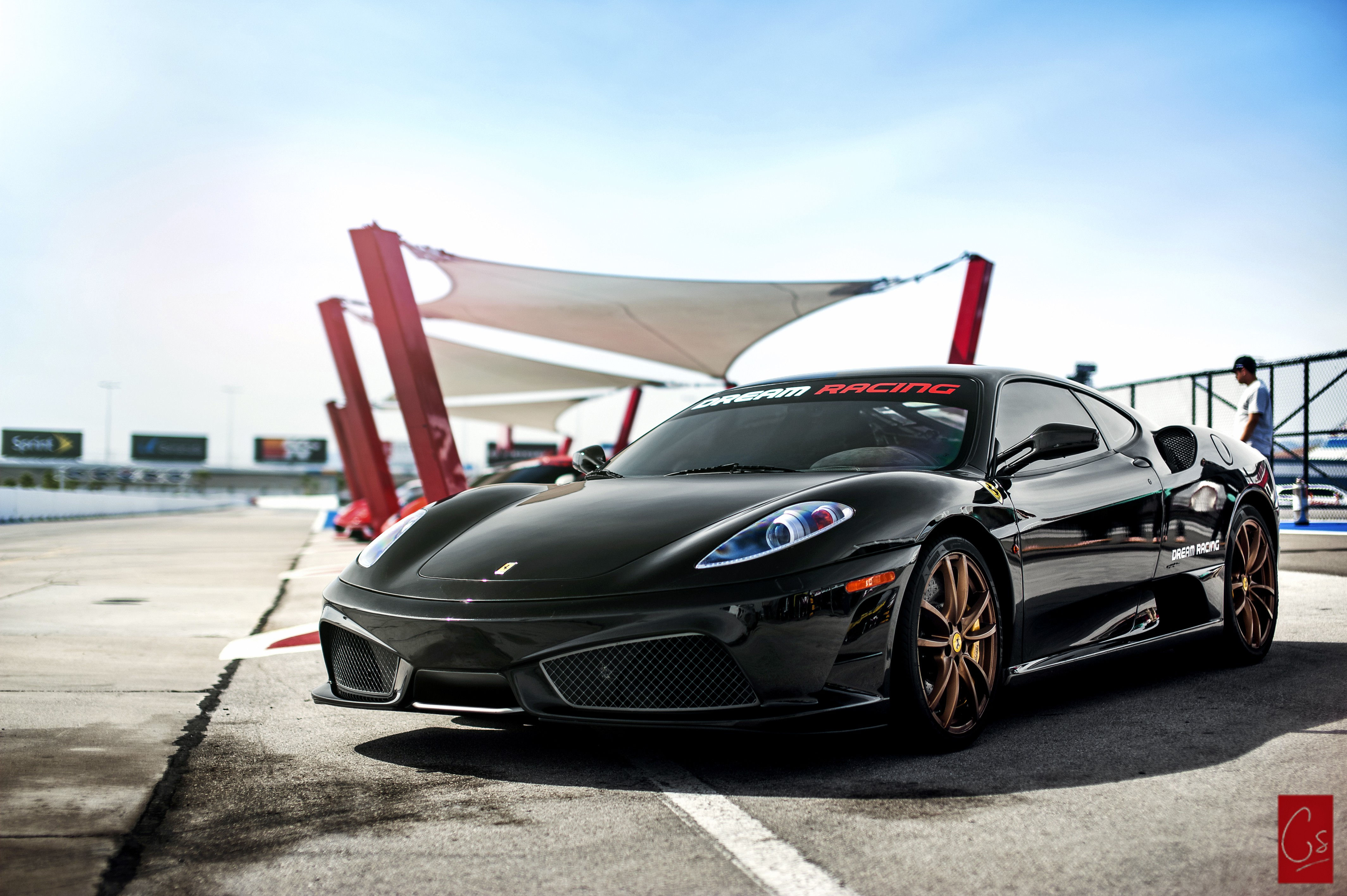 Wallpaper #PUVNlo4B7YBJg1BVH6Dw8 A Sleek Black Ferrari 458 Italia Parked on a Race Track