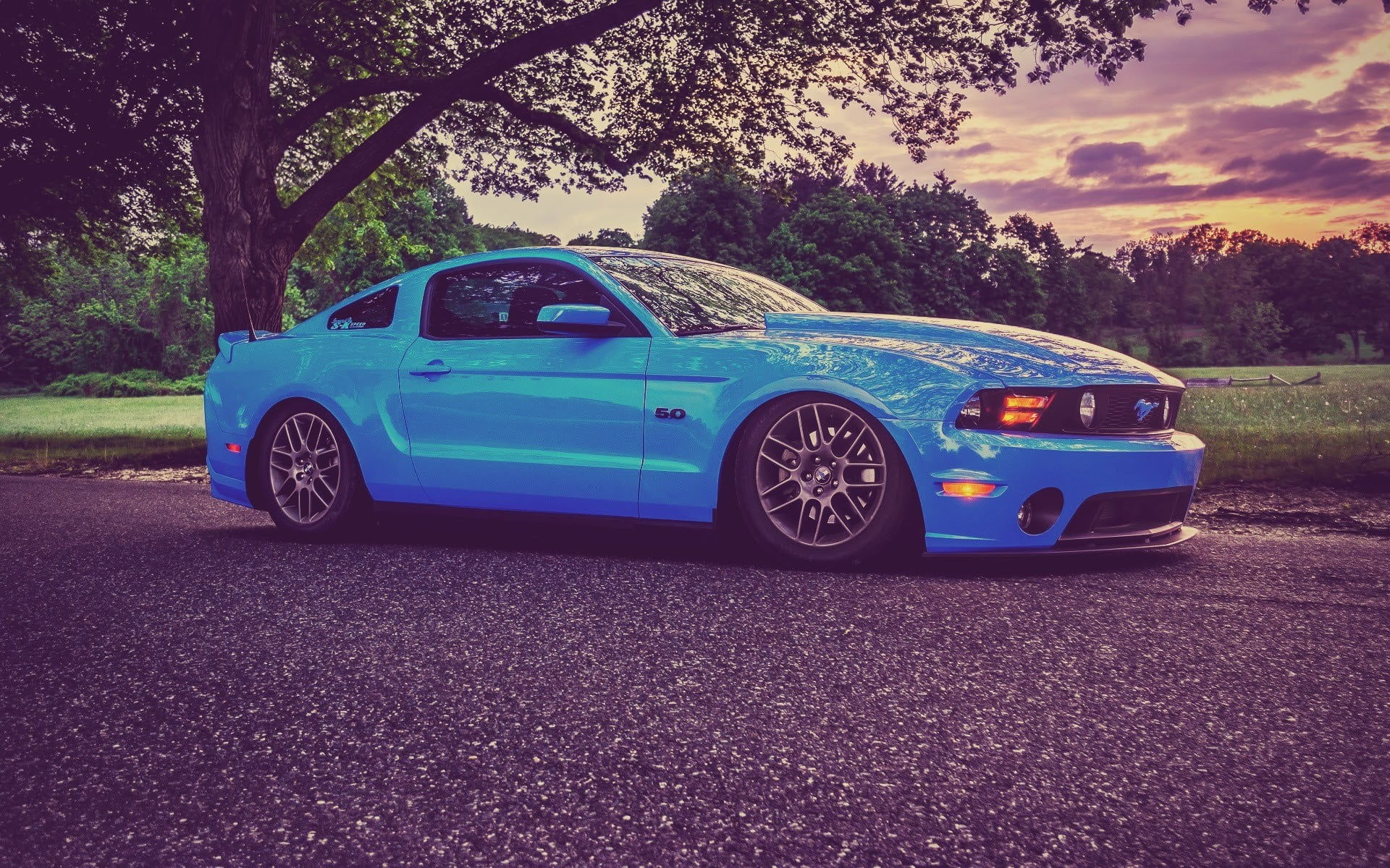 Wallpaper #OHOFgI4BFI5NbQksZRgo29 A Blue Ford Mustang Parked on a Road at Sunset