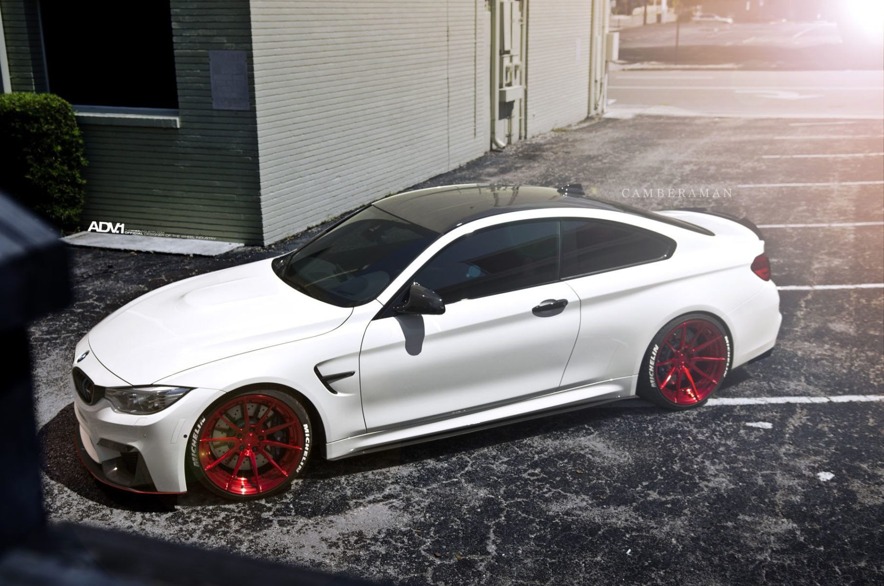 Wallpaper #wnMuiI4BFI5NbQksECES58 A White BMW M4 with Red Rims Parked on the Side of a Road